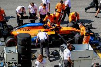Carlos Sainz, McLaren MCL35, on the grid, surrounded by mechanics
