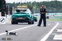 The Medical Car passes Lewis Hamilton as he drives a remote control car