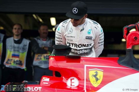 Lewis Hamilton looks at a Ferrari, 2018